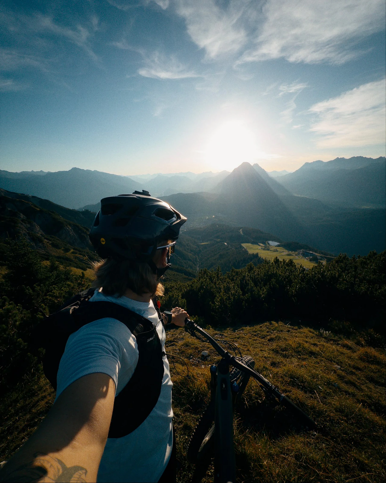 Lukas Ludl mit Rad und Helm am Berg im Abendlicht.