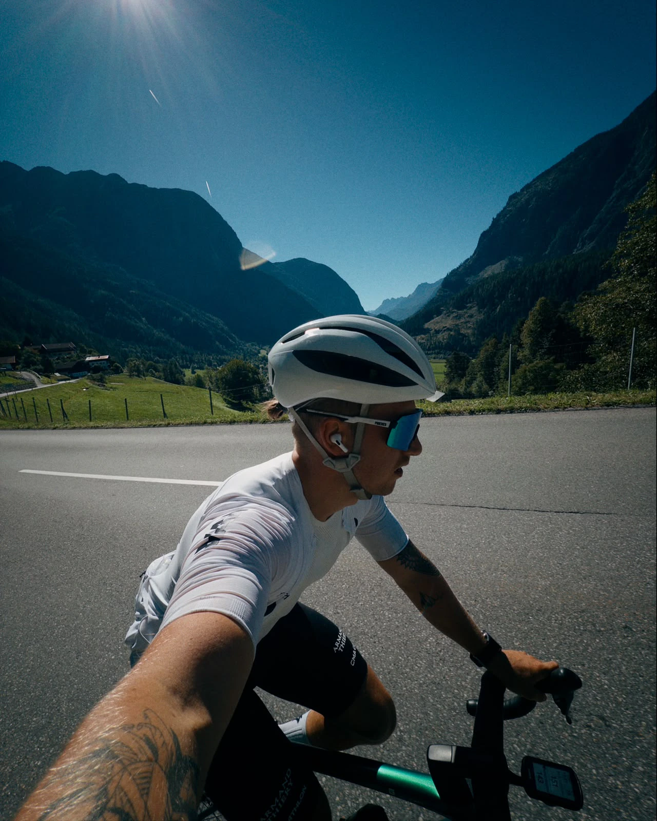 Lukas Ludl auf dem Rennrad auf einer Straße zwischen den Bergen.