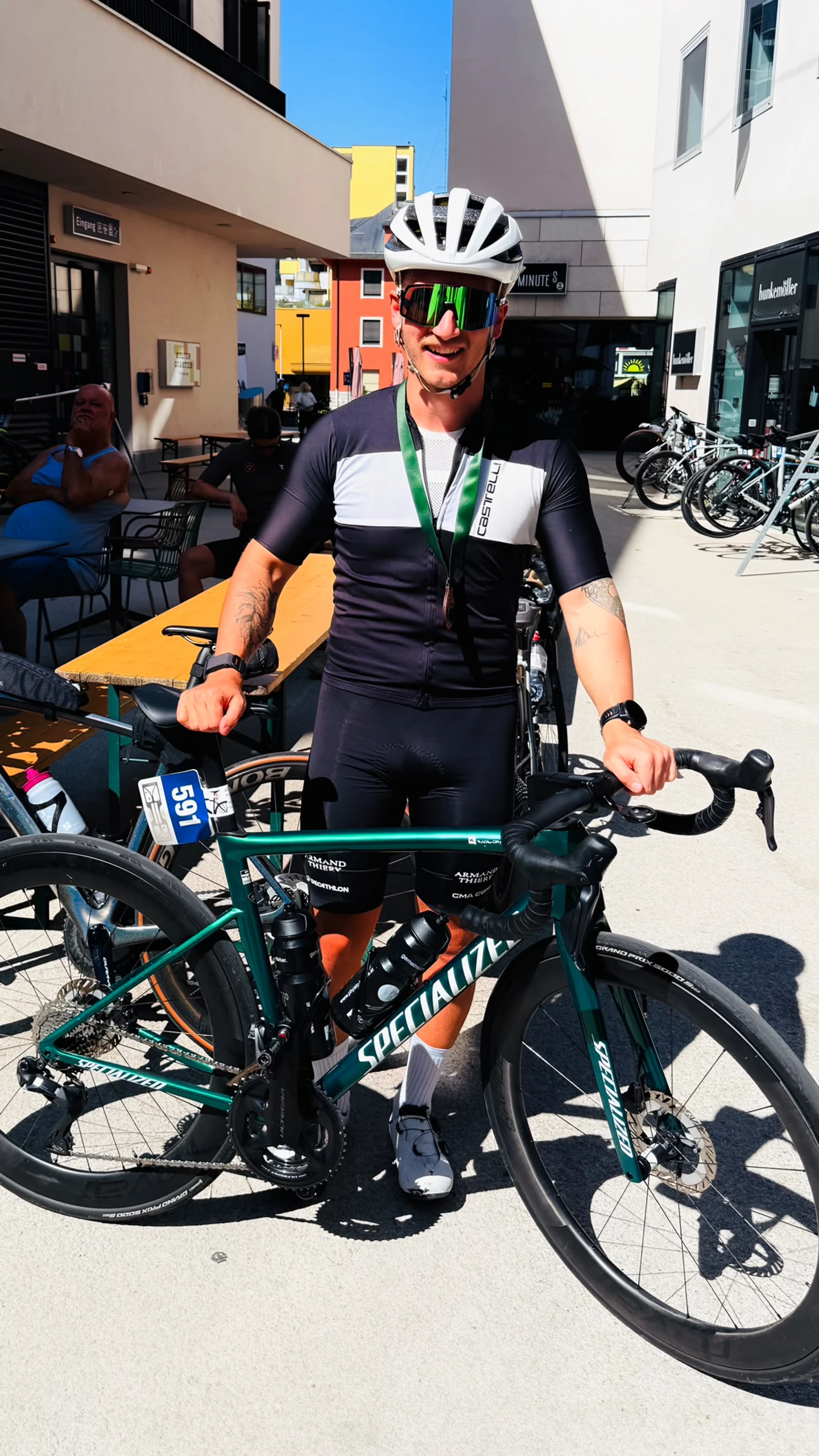 Lukas Ludl mit Helm, Medaille und grünem Rennrad nach einem Wettkampf.